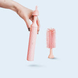 A pink 360 bottle brush with its components displayed in two positions, showing the brush attached to the bottle and separately.